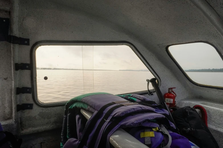 some items and a book bag on the side of a boat