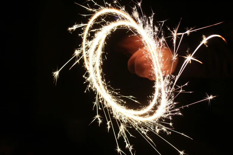 someone holding a small round firework at night