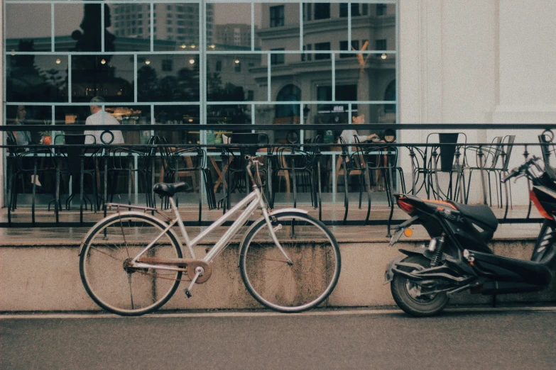 a white bicycle and a silver motor bike