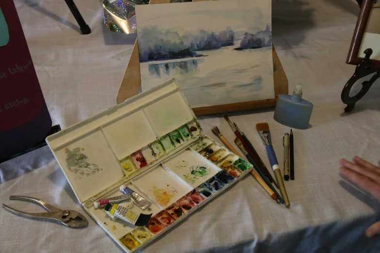 paintings on display at a table with tools nearby