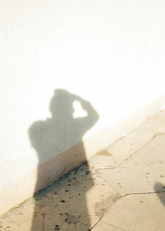 a person with a hat standing next to a wall