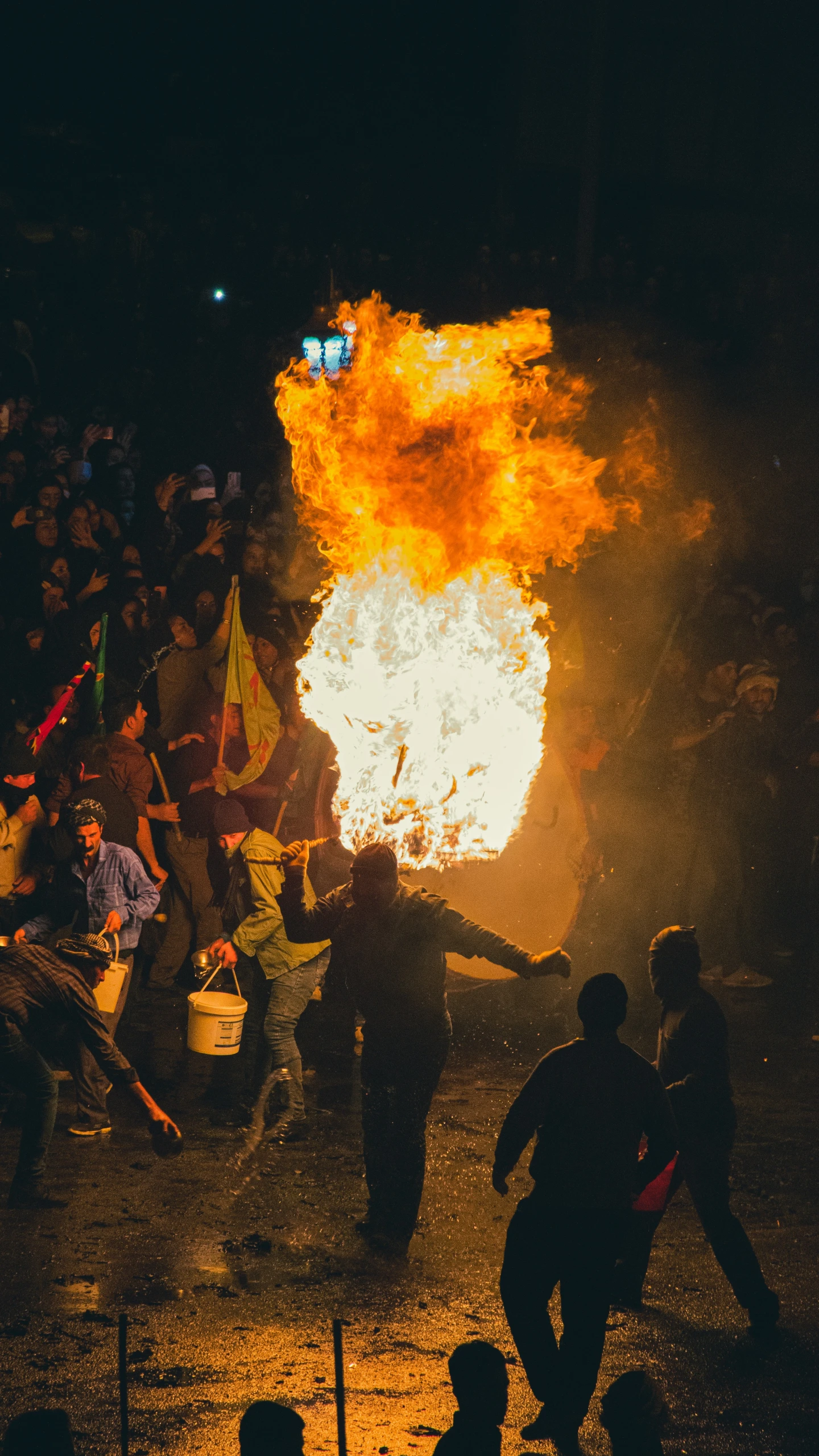 people running around and holding their hands out, as the fire burns