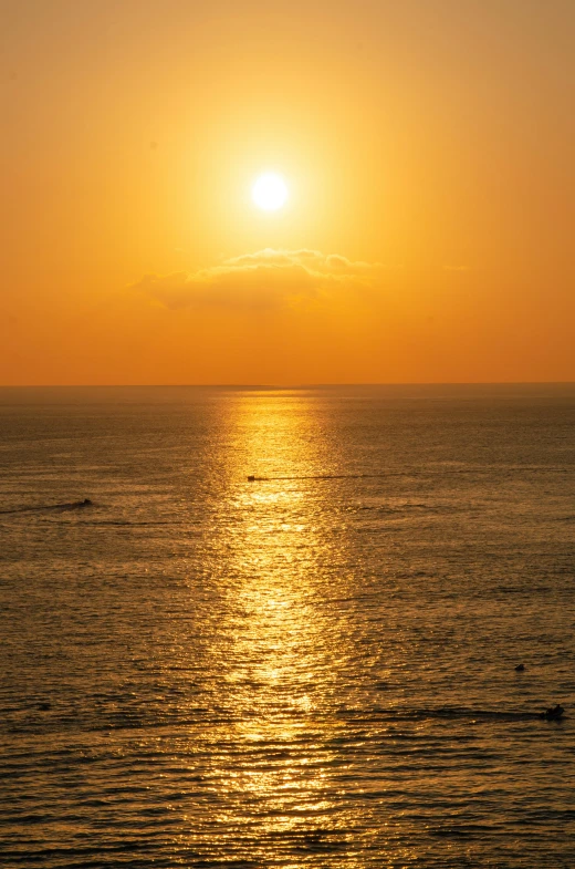 the sun is setting over the water at the beach