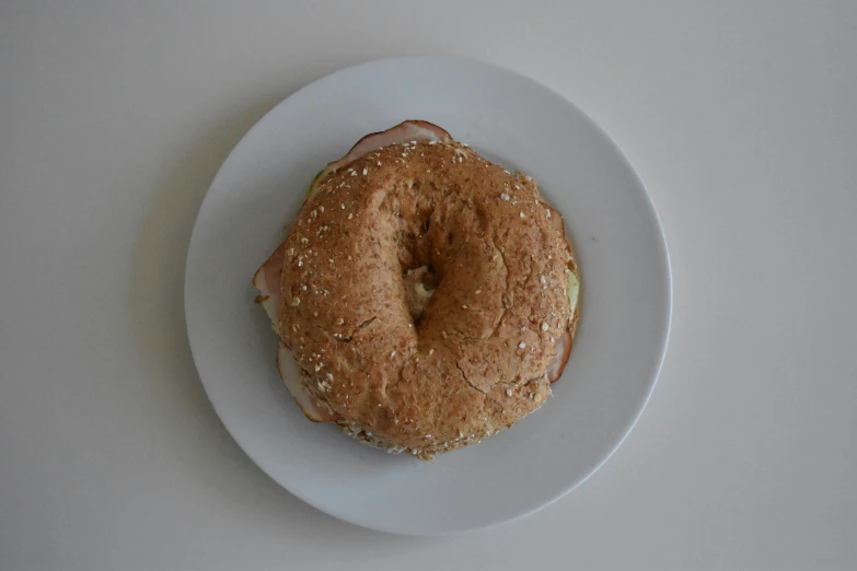 a bagel covered in sesame seed sitting on a plate