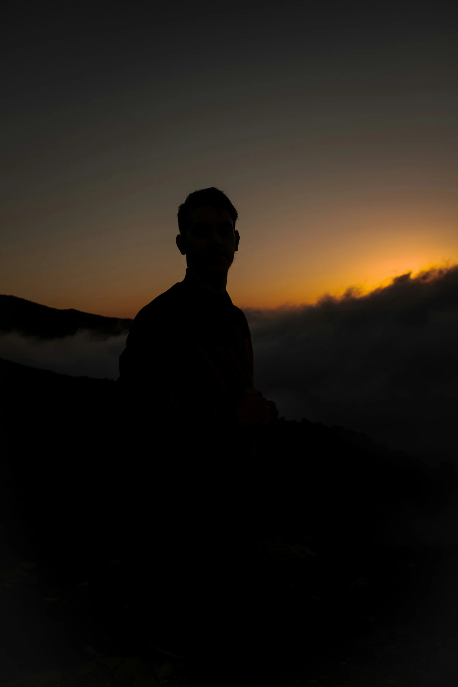 a person is sitting on the ground in the dark