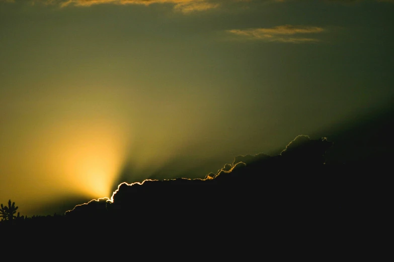 the sun setting over a dark cloud filled sky