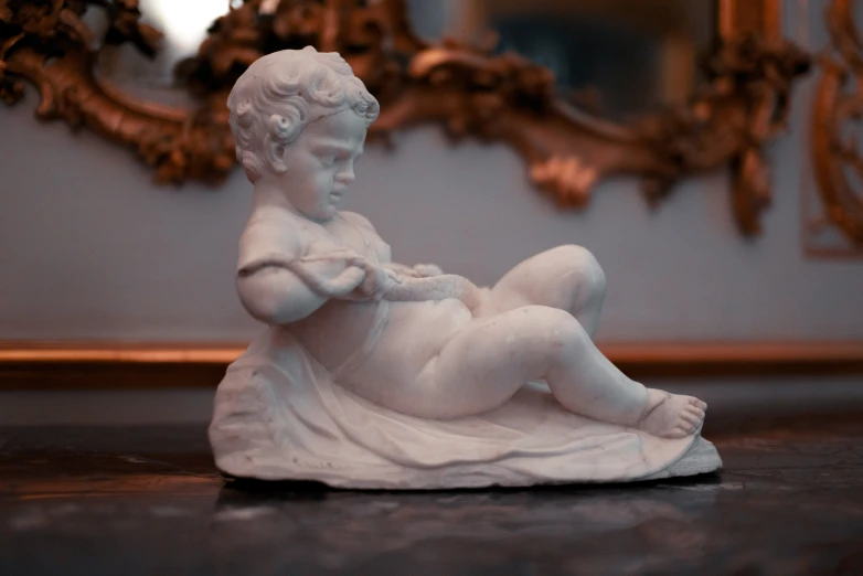 a statue of a woman sitting on a table with a mirror in the background