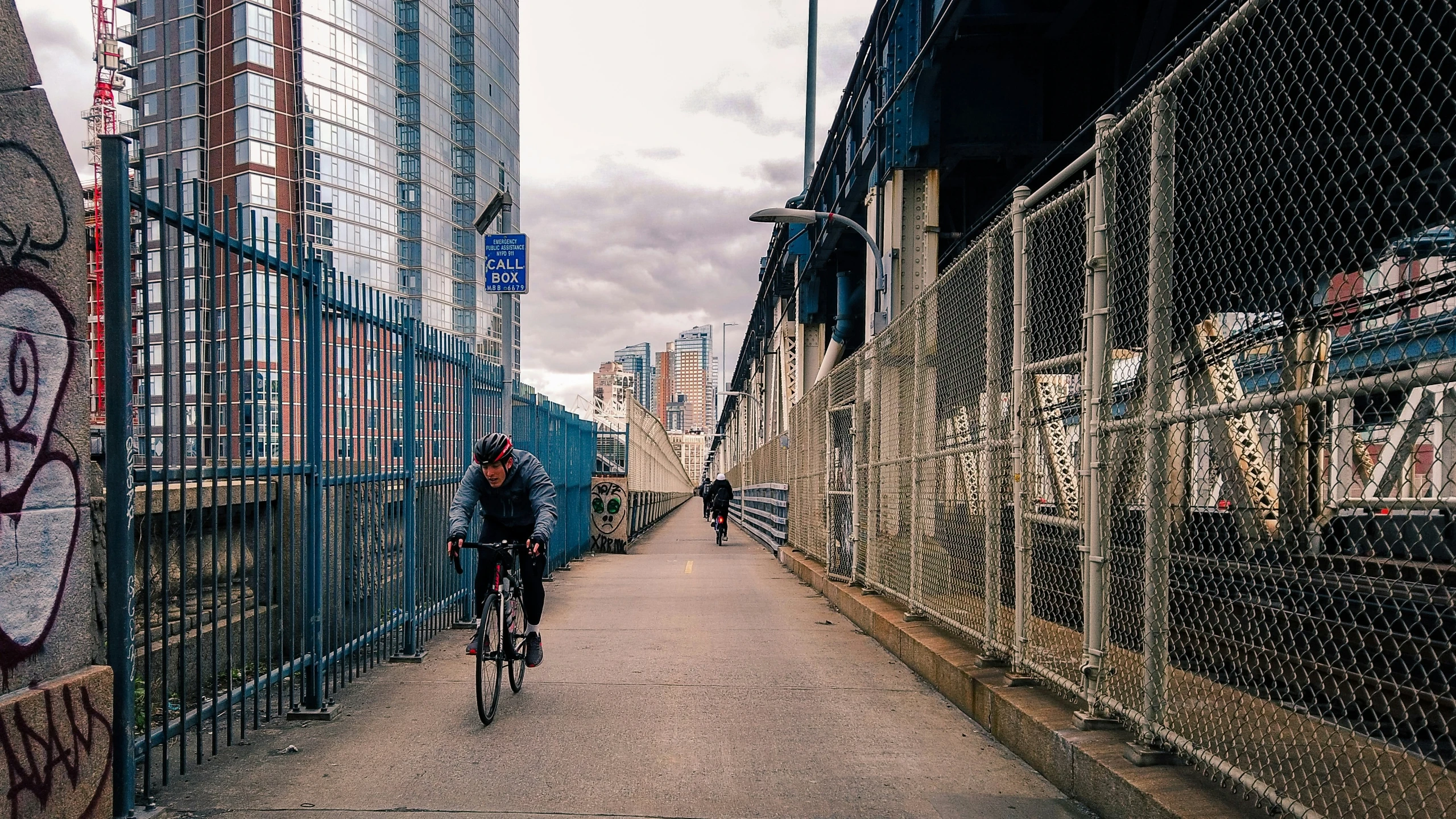 a woman rides a bicycle down an alley