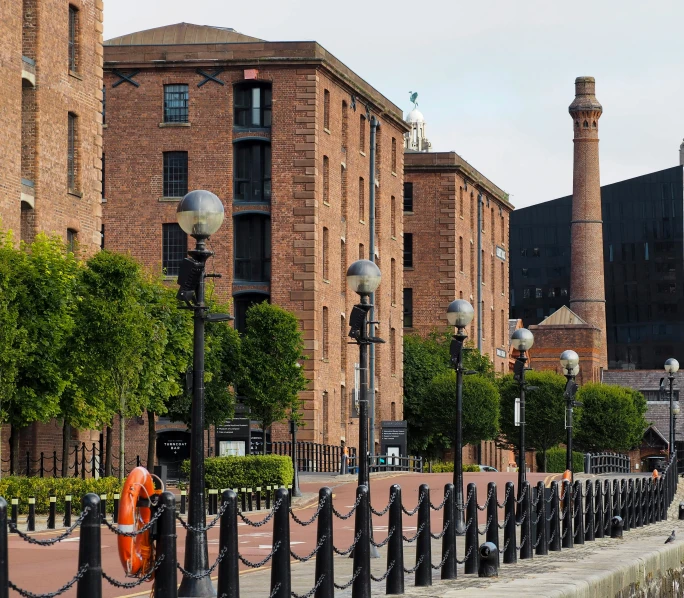 a row of large brick buildings along a street lined with light poles