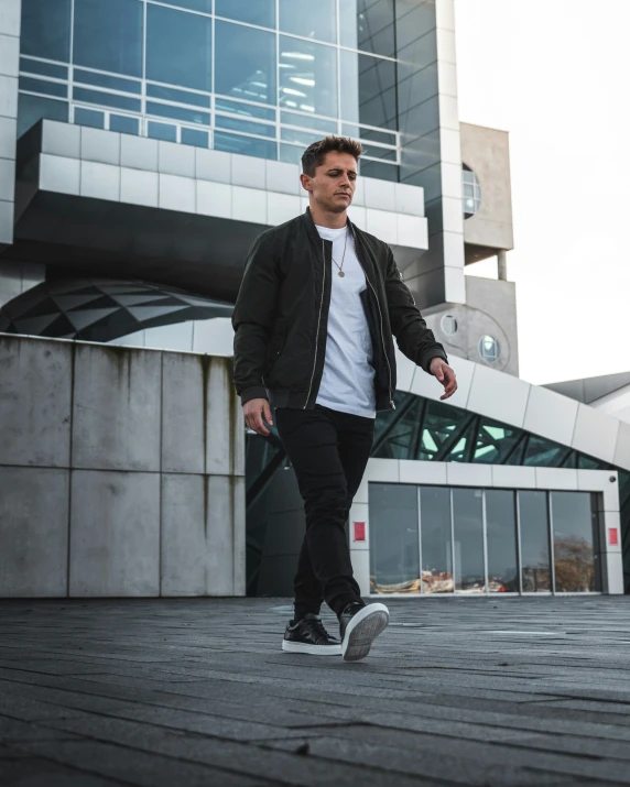 a man walking across a wooden platform with buildings in the background