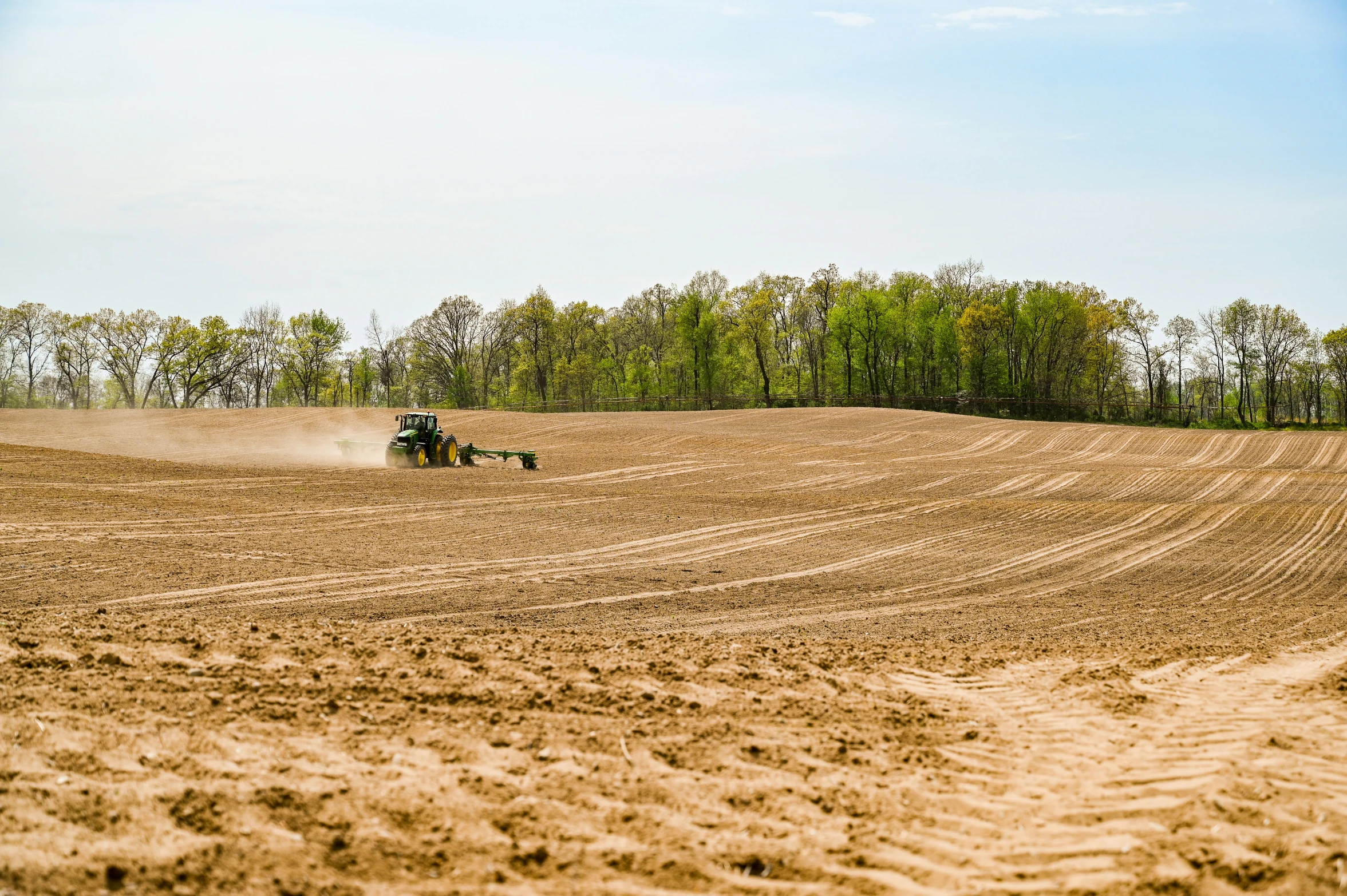 tractor plowing a field on a sunny day