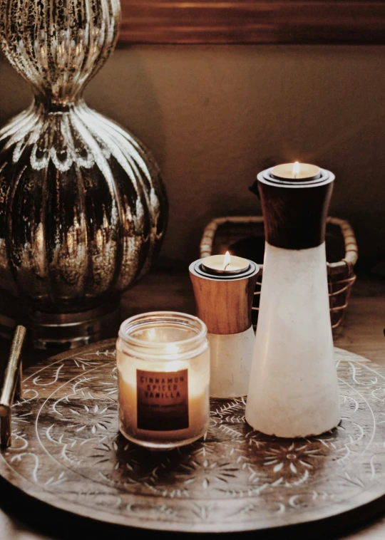 a wooden candle holder sits on a silver tray