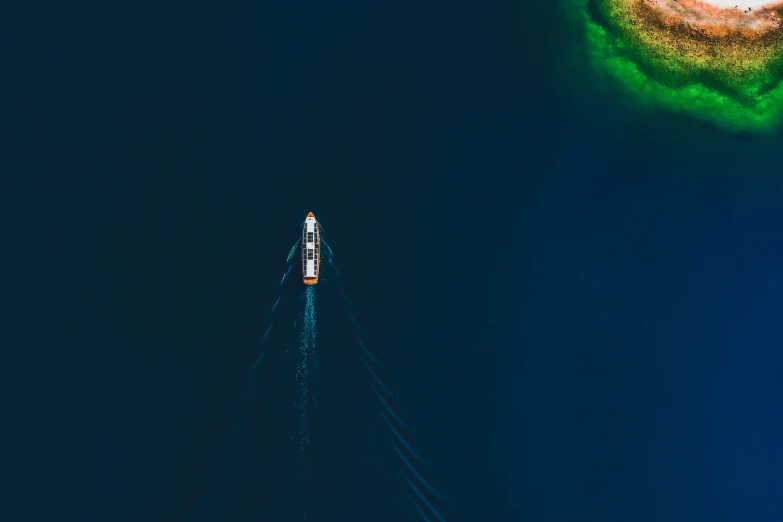 a po taken from above looking down at a boat sailing in the ocean