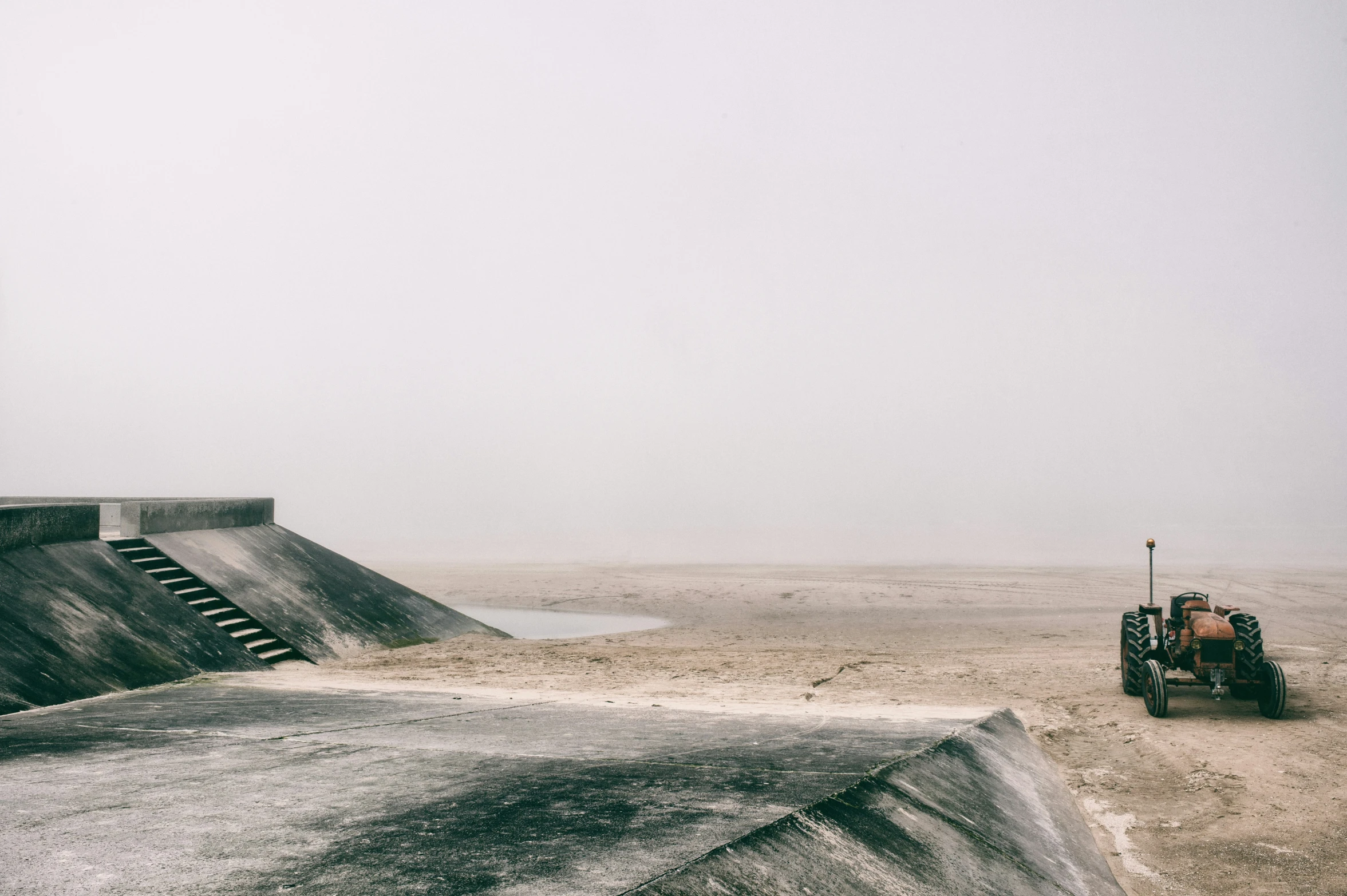 a big concrete ramp sits next to a skate park