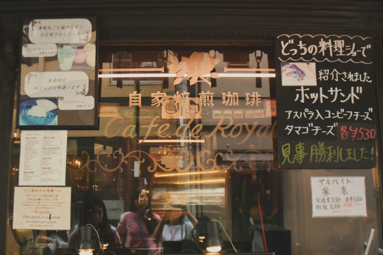 the front of a restaurant window with asian writing on the glass