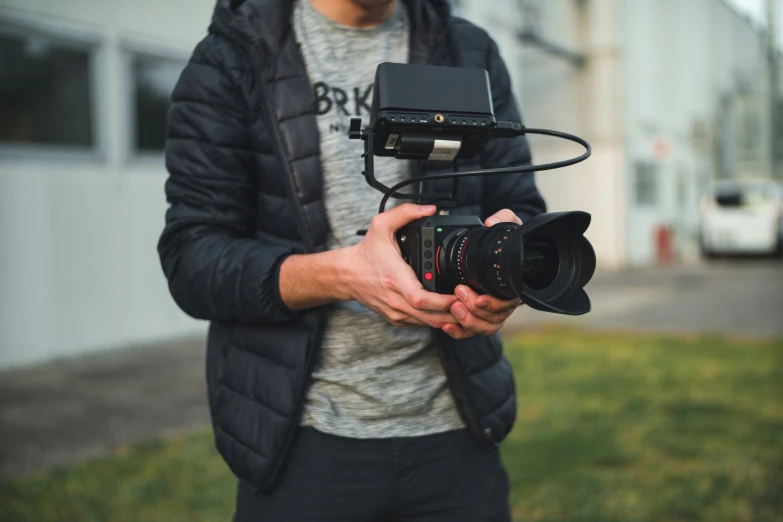 a man holds his camera in one hand and the other