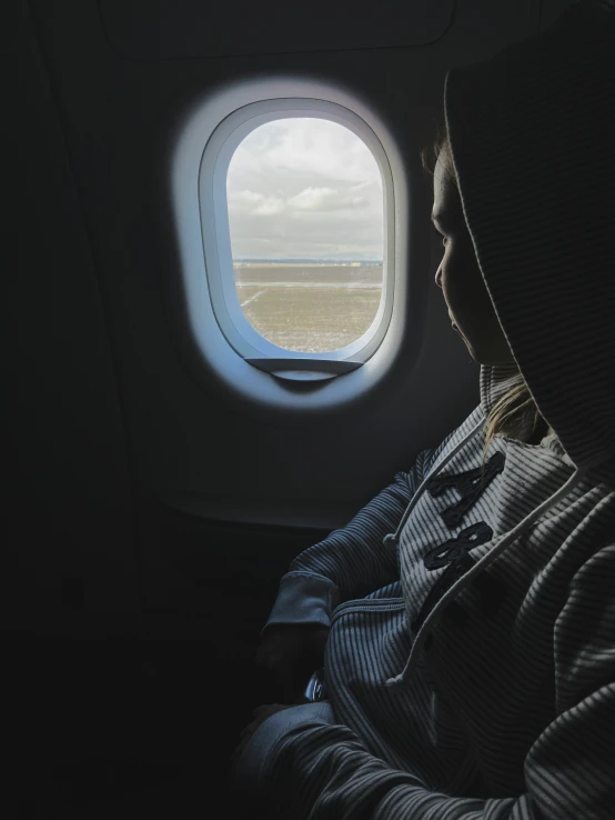 a man looking out a window on an airplane