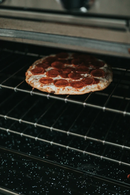 close up of pizza coming out of an oven