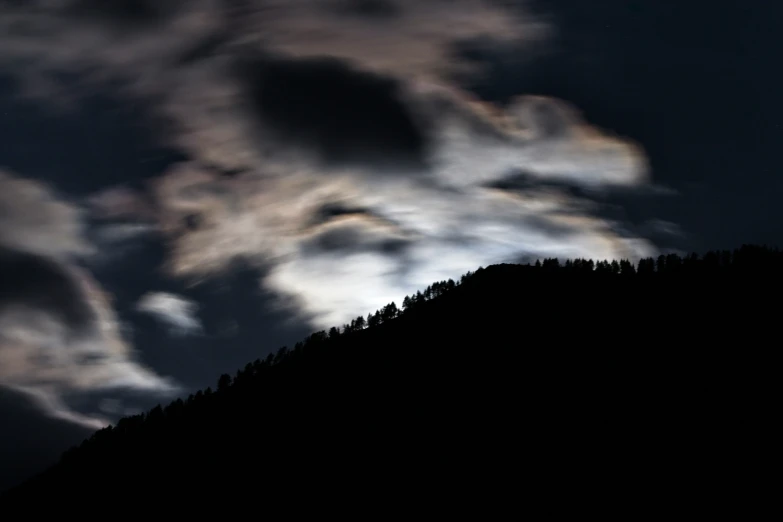 a mountain with a cloud formation in the sky above