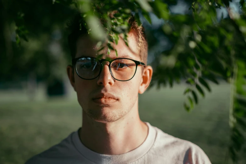 a man with glasses staring up at the camera