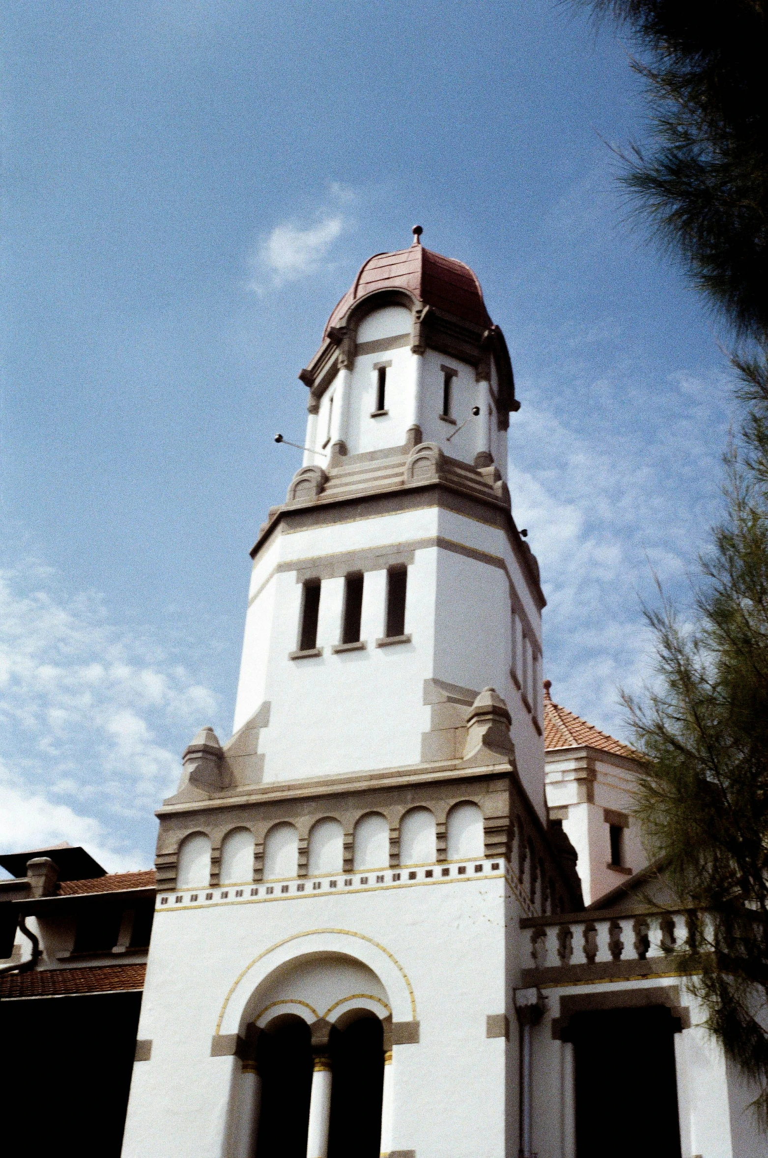 a tall white church tower with a sky background