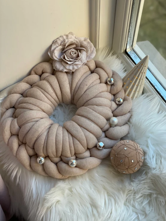 a wreath with pearls, a pink rose on a window sill