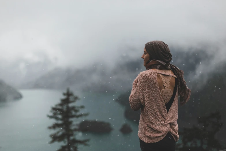 a woman looking out at a mountain lake