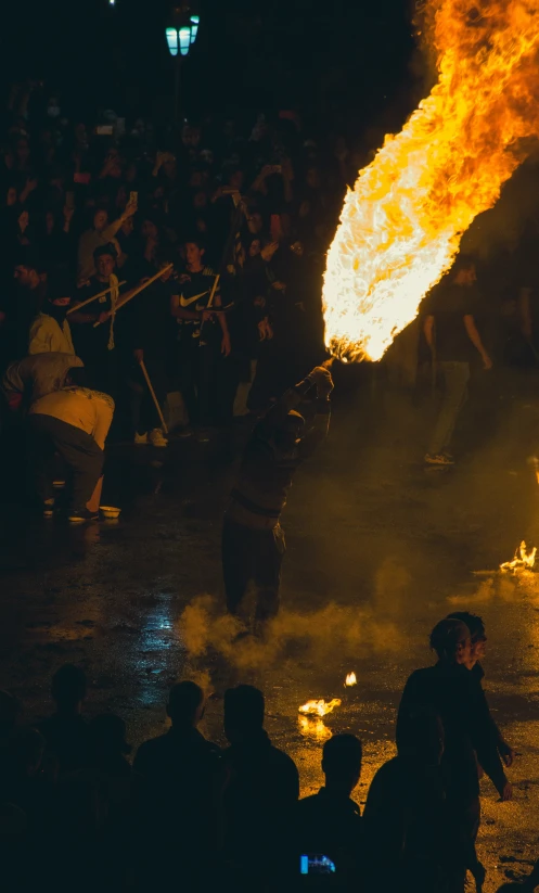 people walk along a street with torches and torches lit