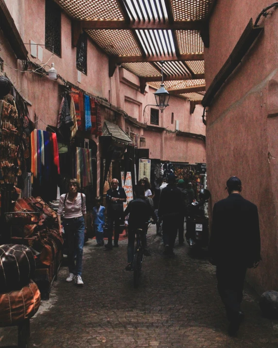 several people are walking through an alley in this picture