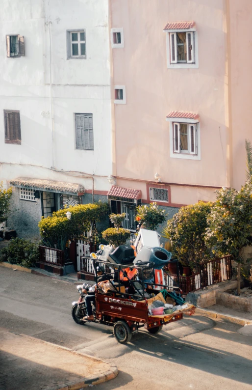 a motor bike pulling a trailer behind it down the street