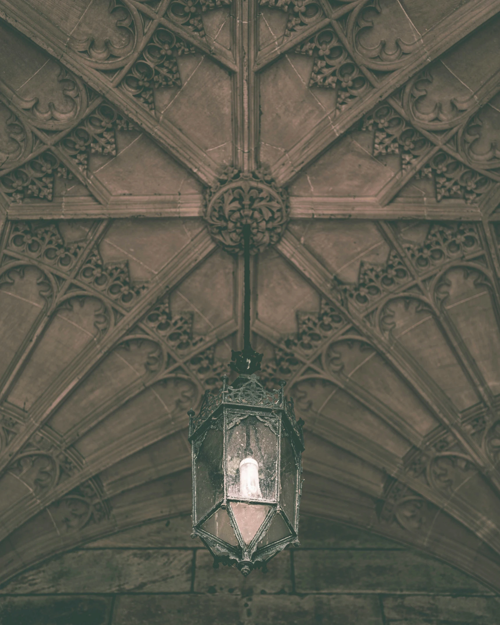 a ceiling in an old building with a lantern hanging from the side