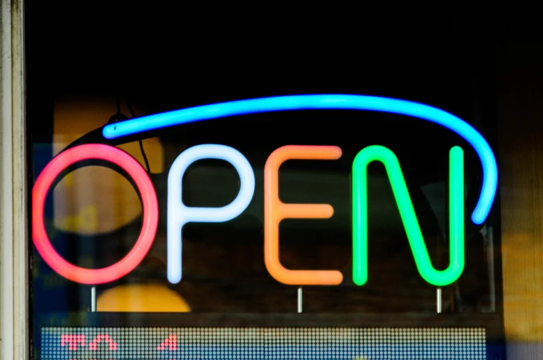 a neon sign sitting in front of a store window