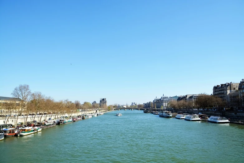 there is a row of boats floating along the river