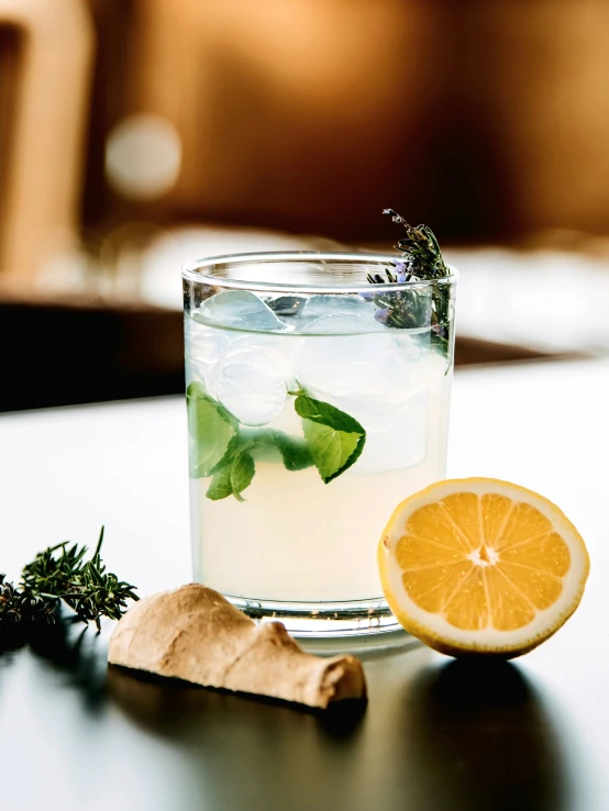 a glass with water sitting next to an orange