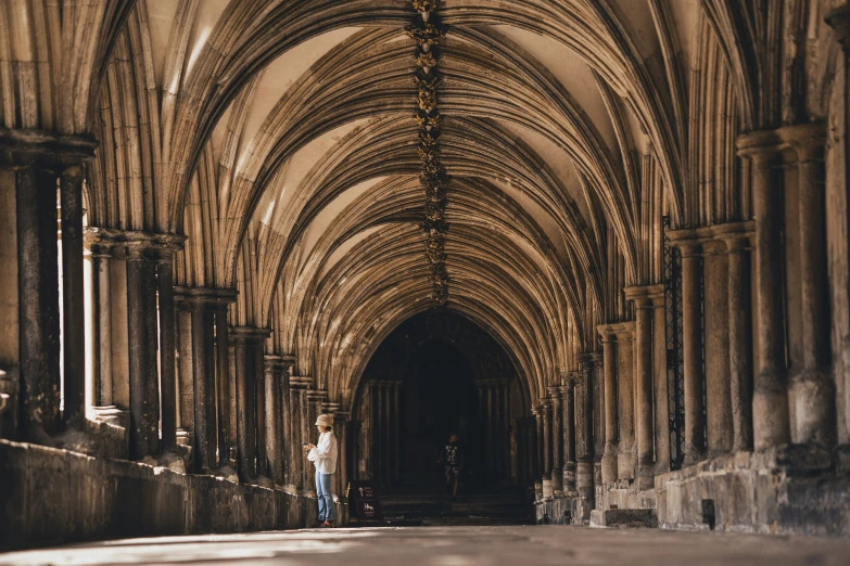 a man stands in an arched stone building