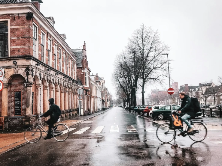 a man riding a bicycle in the rain while he is listening to headphones