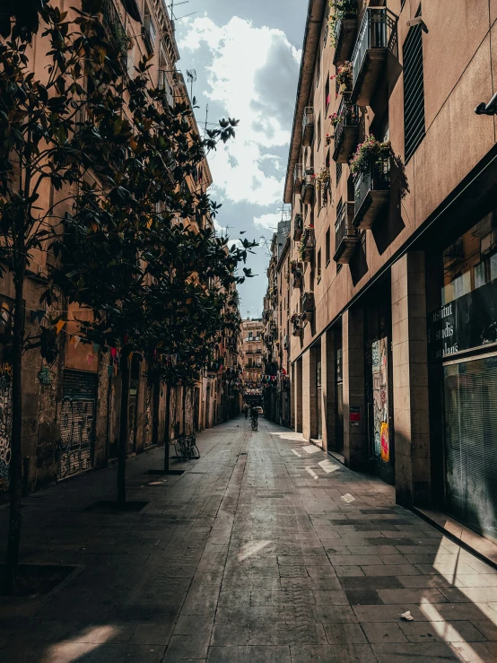 an empty street surrounded by buildings under a cloudy sky