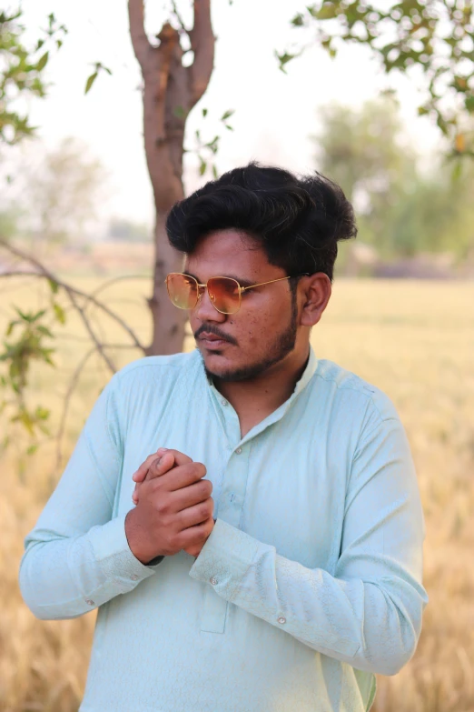 a man in a green shirt stands in a field