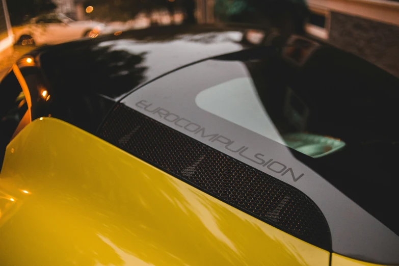 a yellow sport car is parked on the road