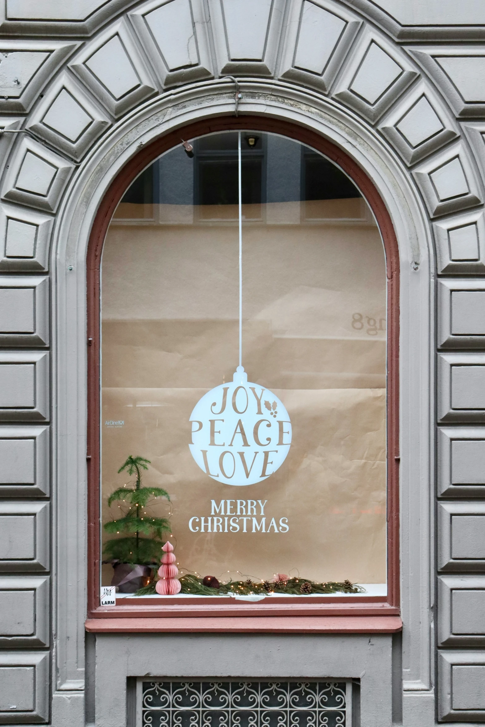 a window of a business with a merry christmas sign behind the window