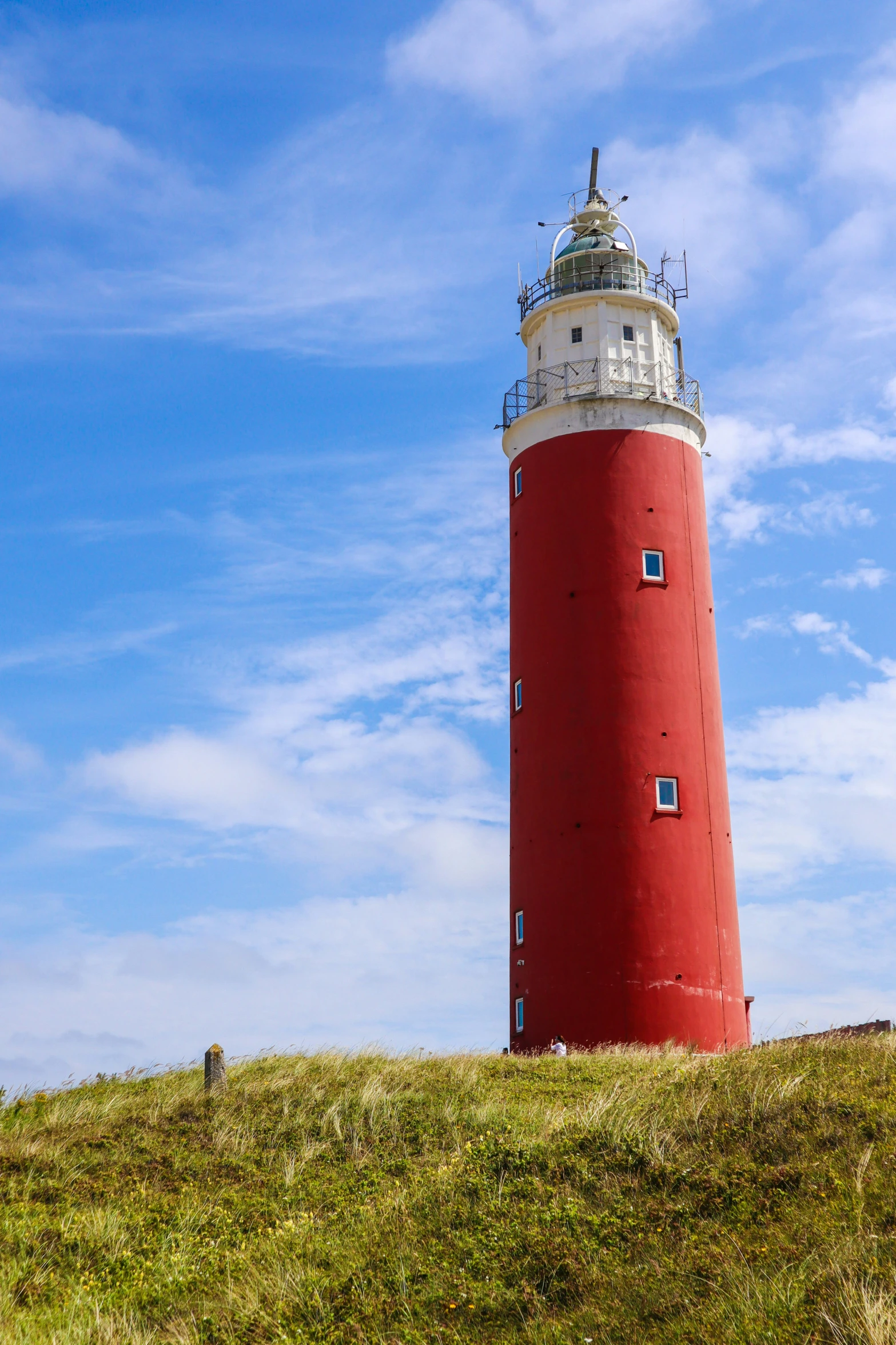 a lighthouse stands on top of a hill