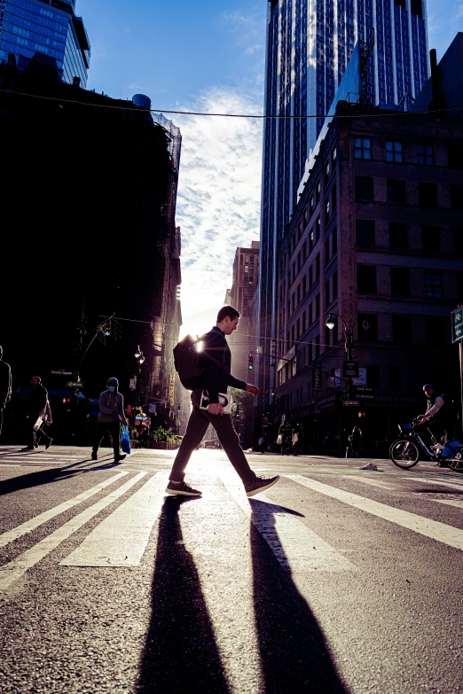 a man walking down the street in the middle of a city