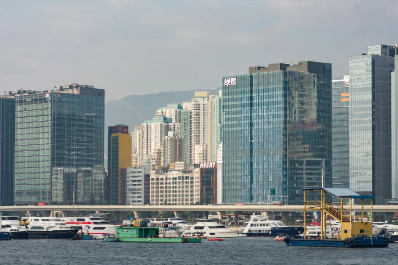 many different boats are on the water in front of tall buildings