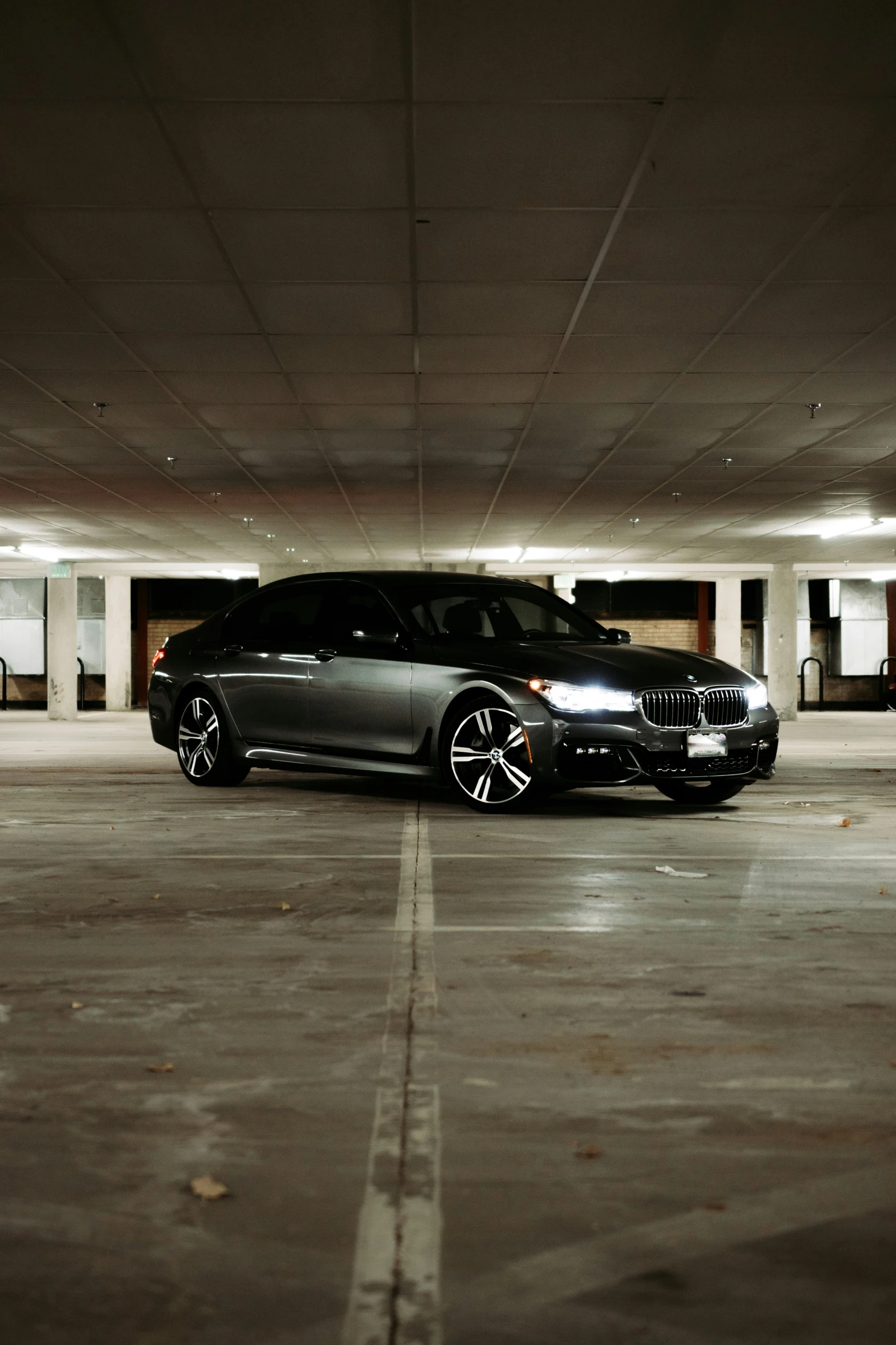 a couple of very shiny cars parked in a parking garage