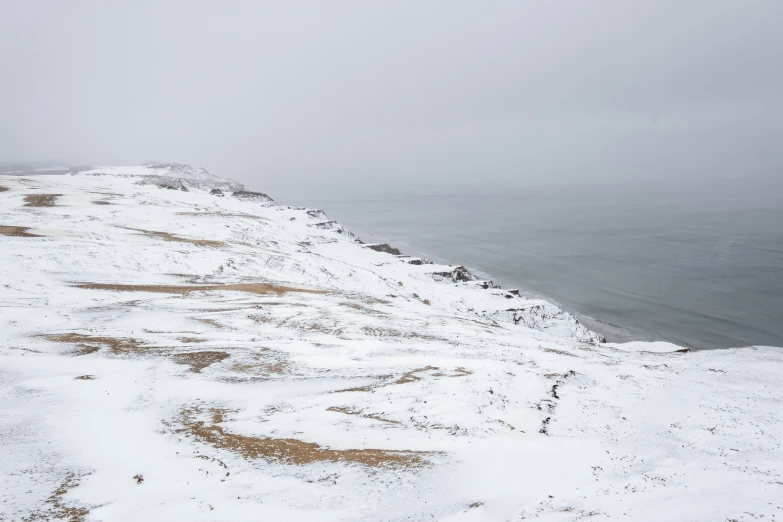 a snow - covered hill with a few very steep sides on the water