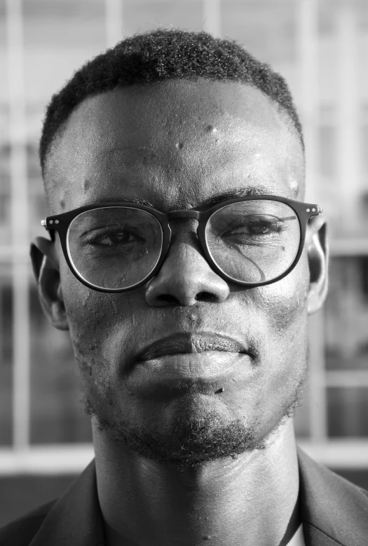 a man in suit and glasses posing for a po