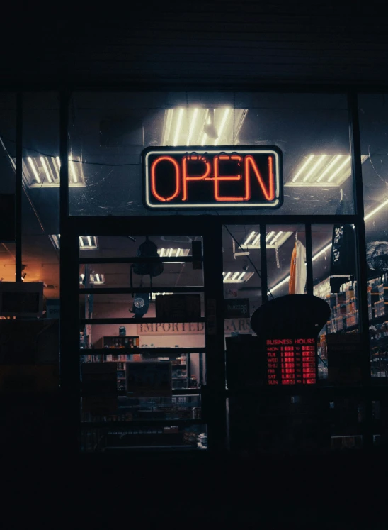 an open sign at the front of a business with lots of products