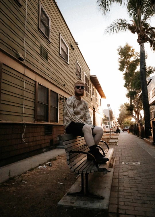 a person sitting on top of a bench near some trees