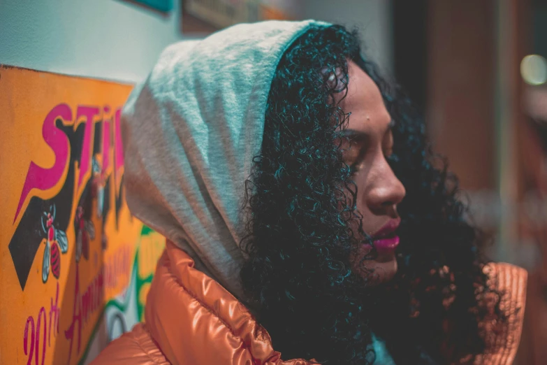 a young woman looking down at her hooded jacket