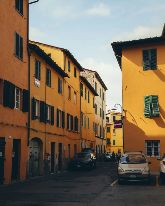 an old city street lined with tall yellow buildings